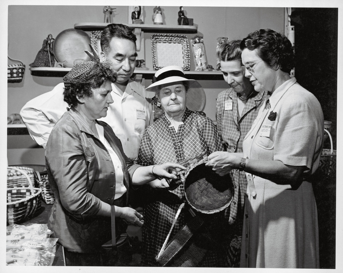 Four women admire a double woven basket 
